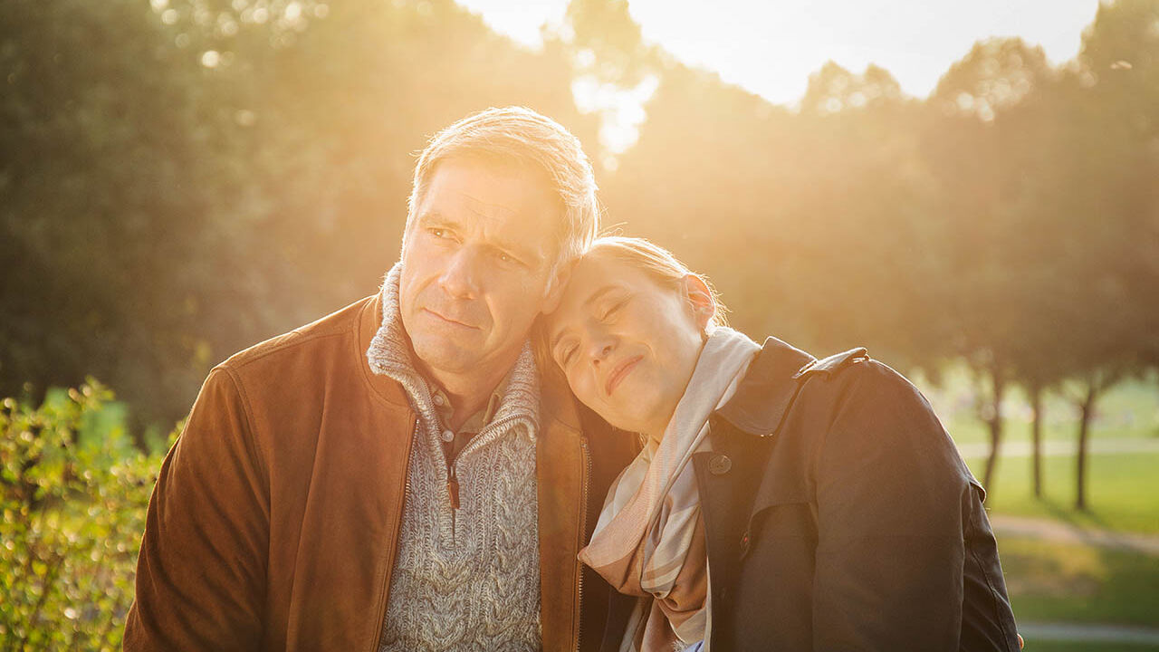 Ein Paar sitzt gemeinsam im Park und genießen die Zeit zusammen.
