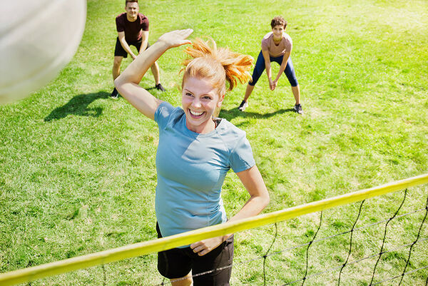 Junge Leute spielen Volleyball im Park