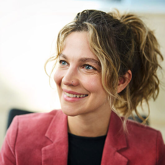 Eine Frau lächelt ihren Gesprächspartner an.