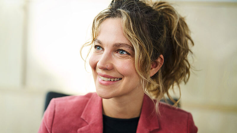 Eine Frau lächelt ihren Gesprächspartner an.