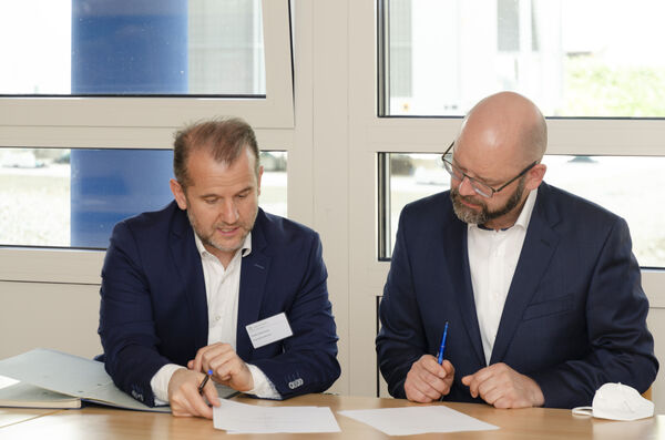 Zwei Männer unterzeichnen einen Vertrag