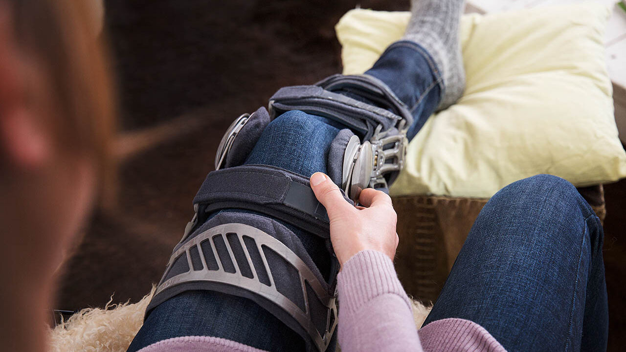 Eine Frau trägt eine Schiene am linken Bein.