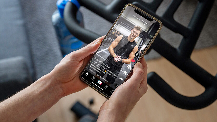 Frau schaut Fitnessübung auf Smartphone