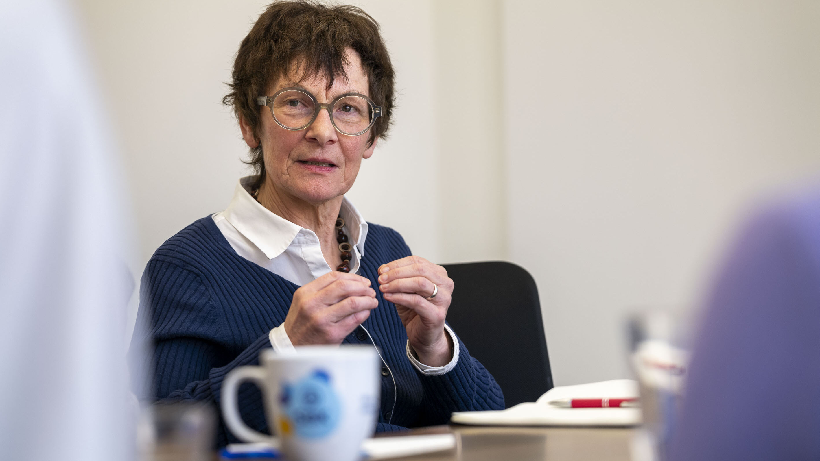 SBK-Vorständin Dr. Gertrud Demmler sitzt an einem Tisch und diskutiert mit anderen Menschen