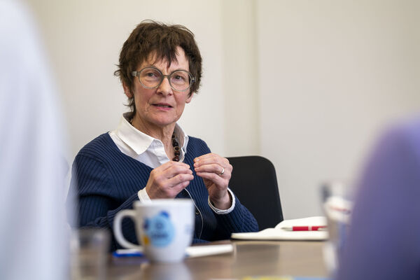 SBK-Vorständin Dr. Gertrud Demmler sitzt an einem Tisch und diskutiert mit anderen Menschen