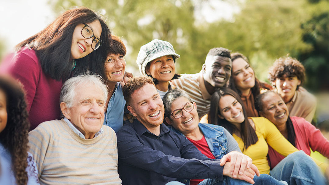 Diverse Menschen sitzen zusammen und sind fröhlich