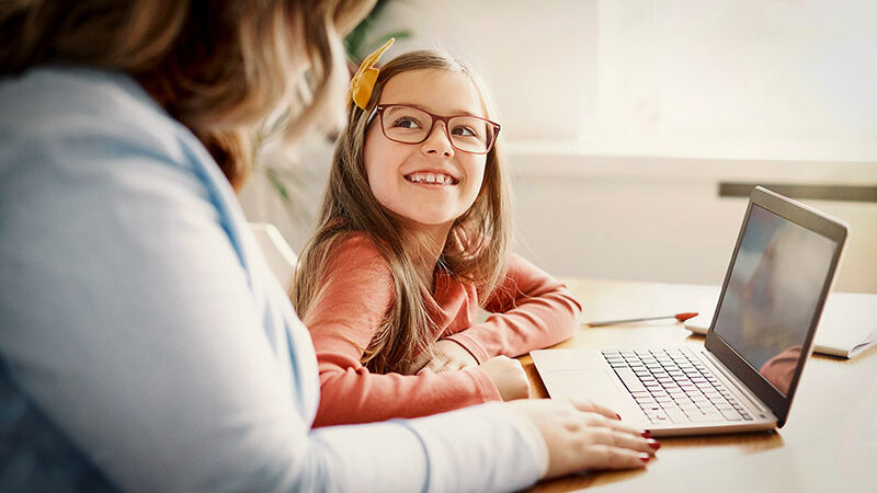 Kind mit Brille am Laptop