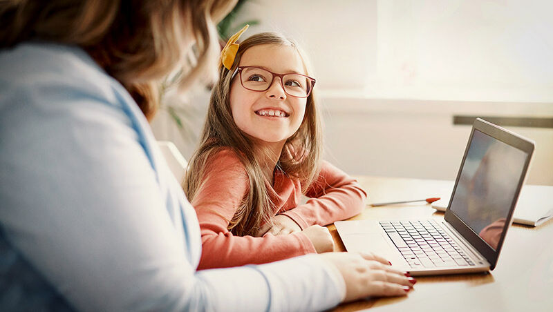 Kind mit Brille am Laptop