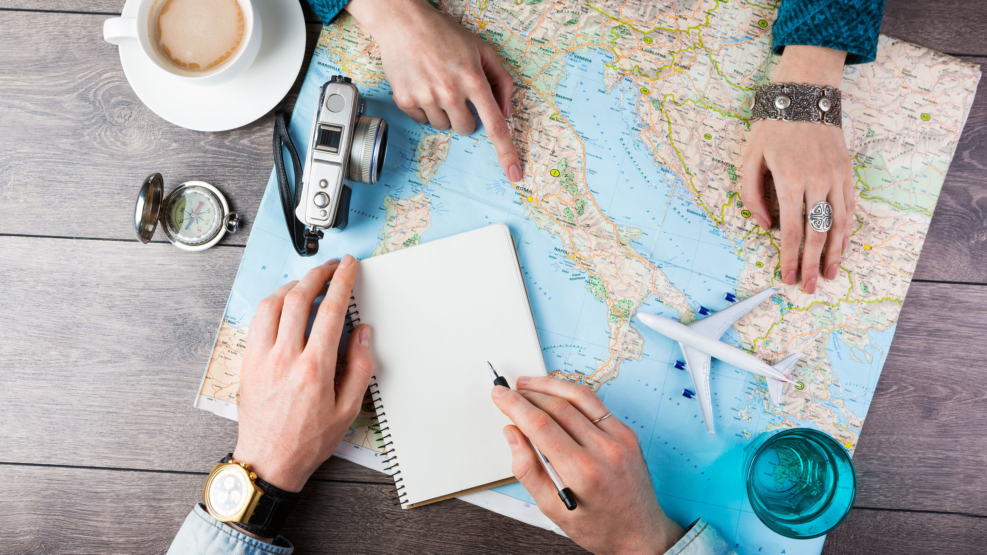 Zwei Personen suchen Reiseziele auf einer Weltkarte