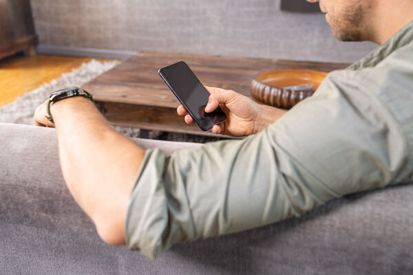 Mann blickt auf sein Handy