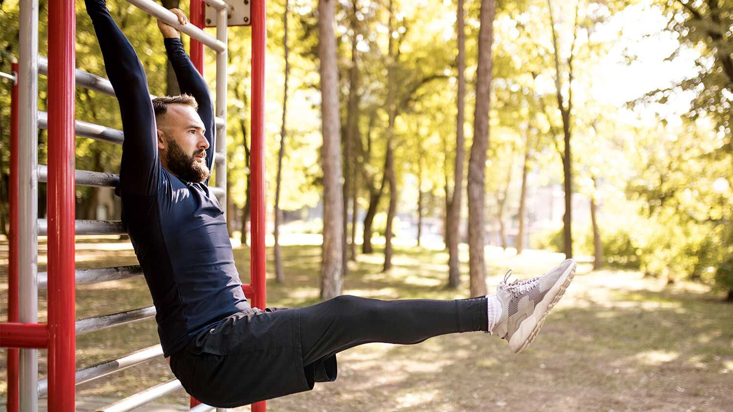 Mann macht sport am Gerüst im Park