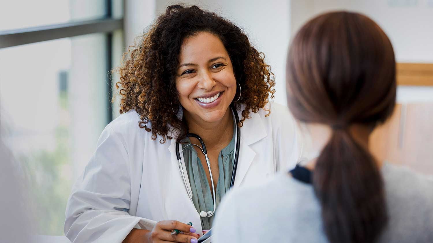 Ärztin hört einer Patientin zu