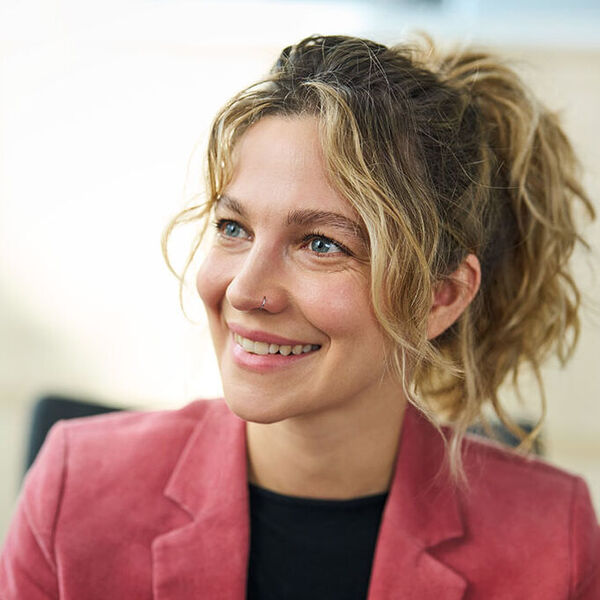 Eine Frau lächelt ihren Gesprächspartner an.