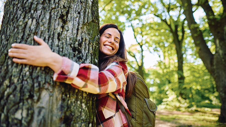 Frau umarmt einen Baum