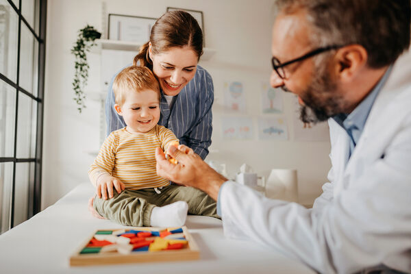 Kind mit Mutter bei Vorsorgeuntersuchung beim Kinderarzt