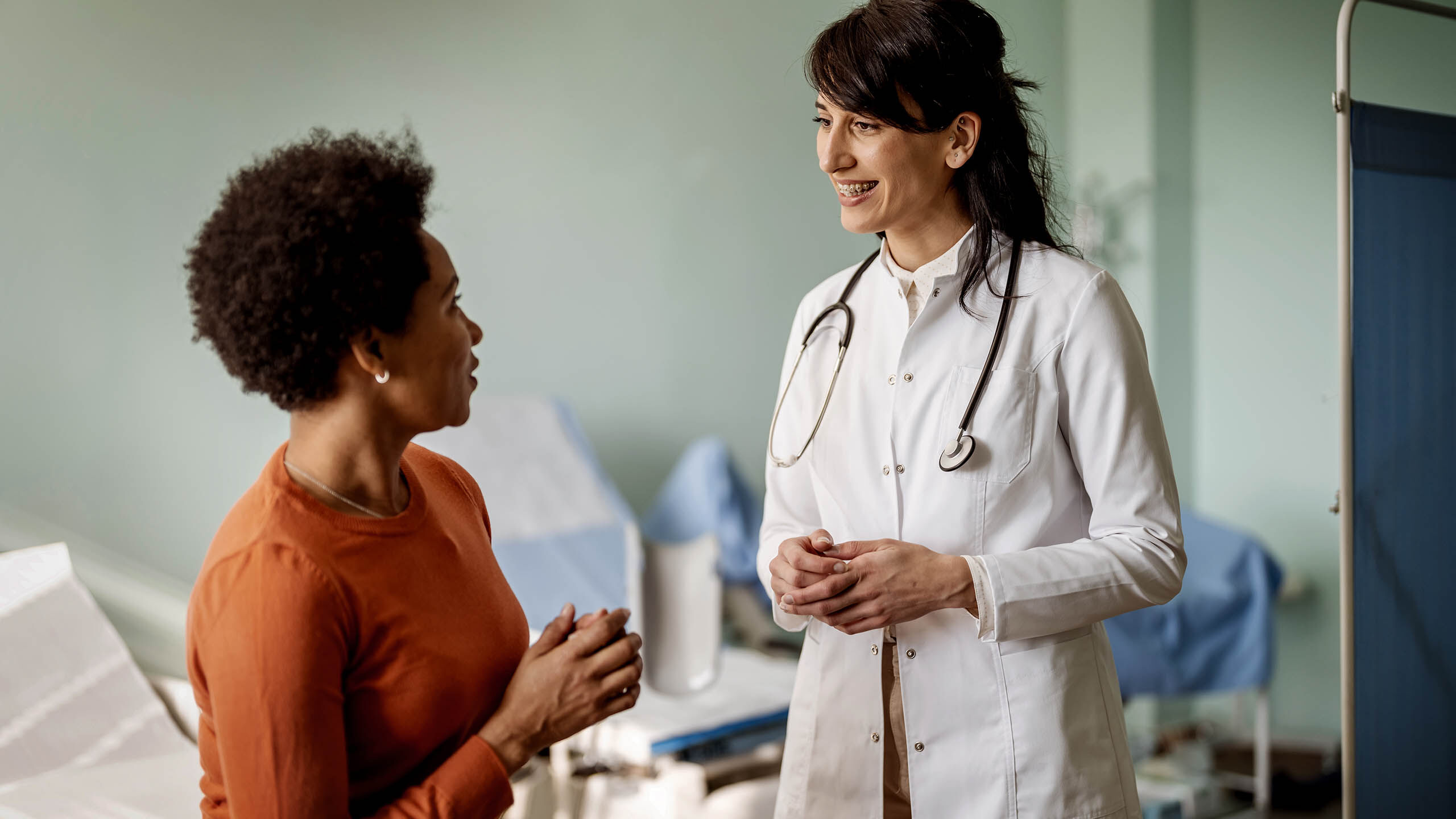 Eine Ärztin unterhält sich mit ihrer weiblichen Patientin im Behandlungsraum.