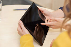 Eine Hand zeigt auf ein Tablet