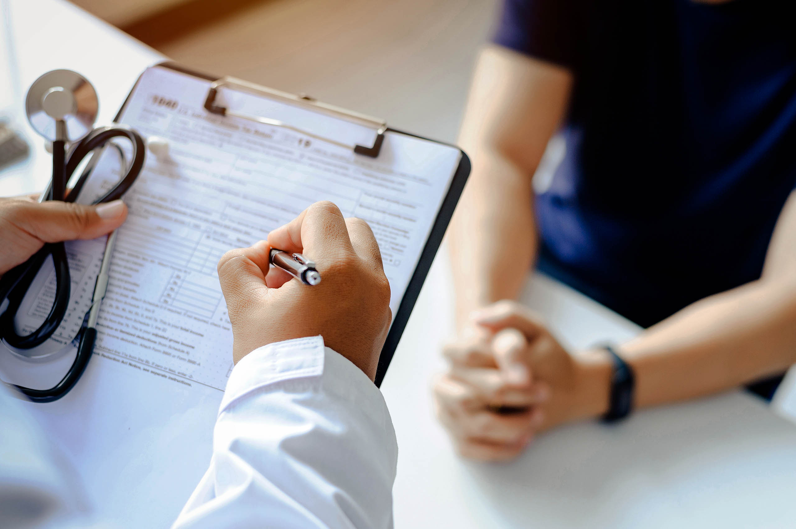 Ein Arzt füllt ein Dokument mit seinem Patienten aus. 