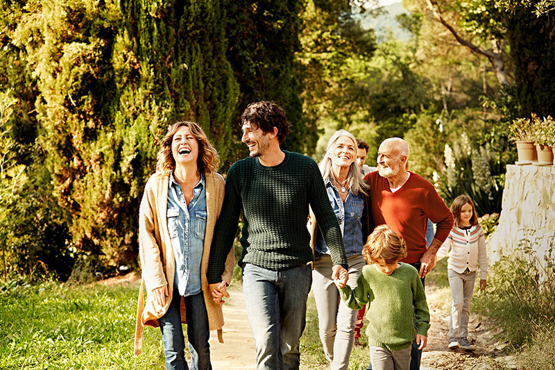 Eine große Familie ist gemeinsam in der Natur spazieren, sie lachen gemeinsam.