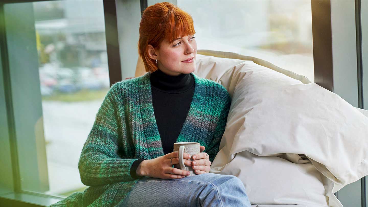 Frau schaut aus dem Fenster.