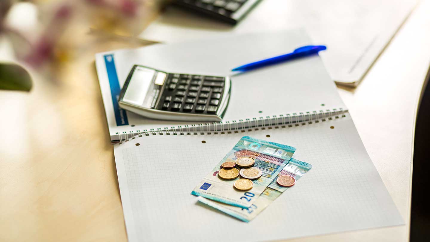 On a desk lies a calculator and money