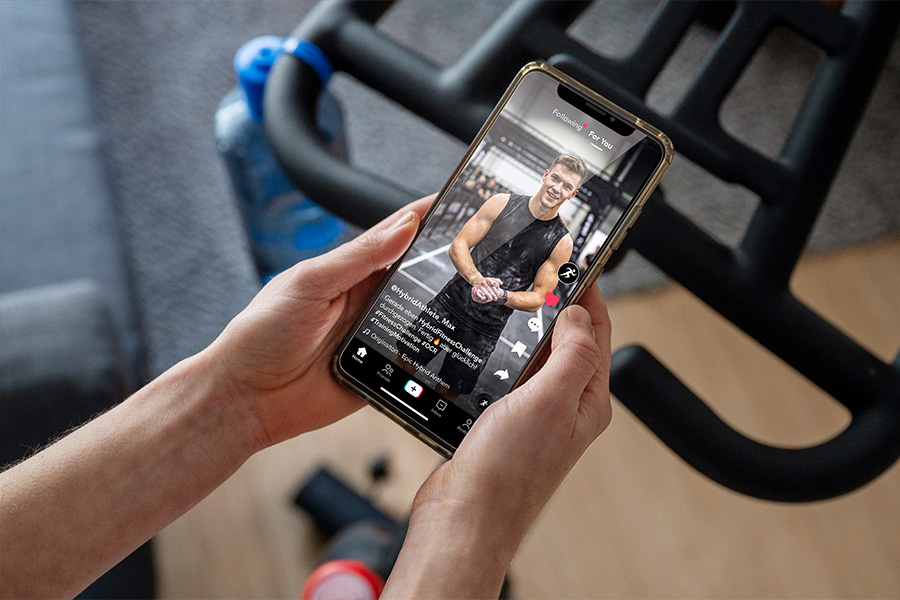 Frau schaut Fitnessübung auf Smartphone