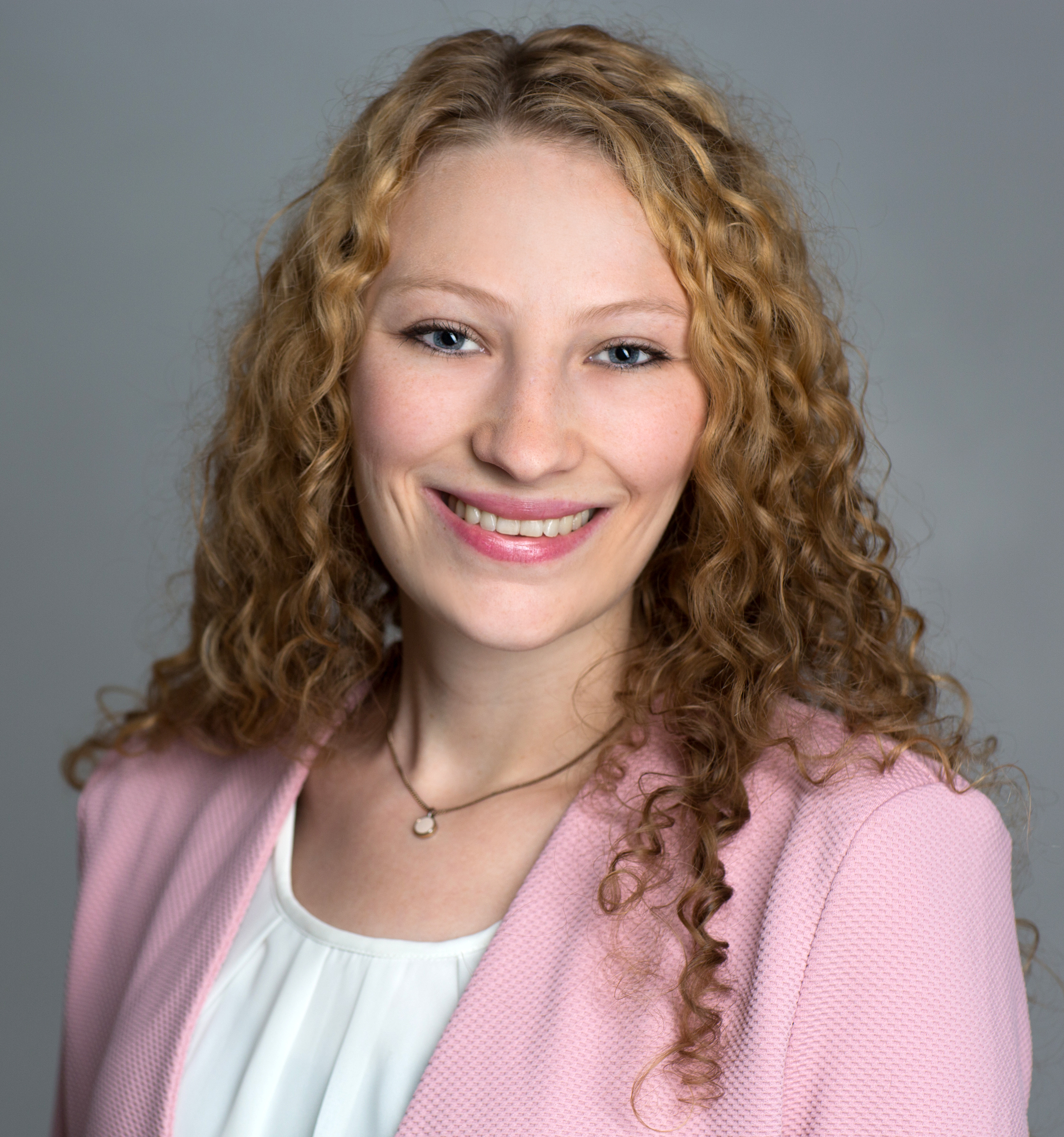 Frau lächelt in Kamera.