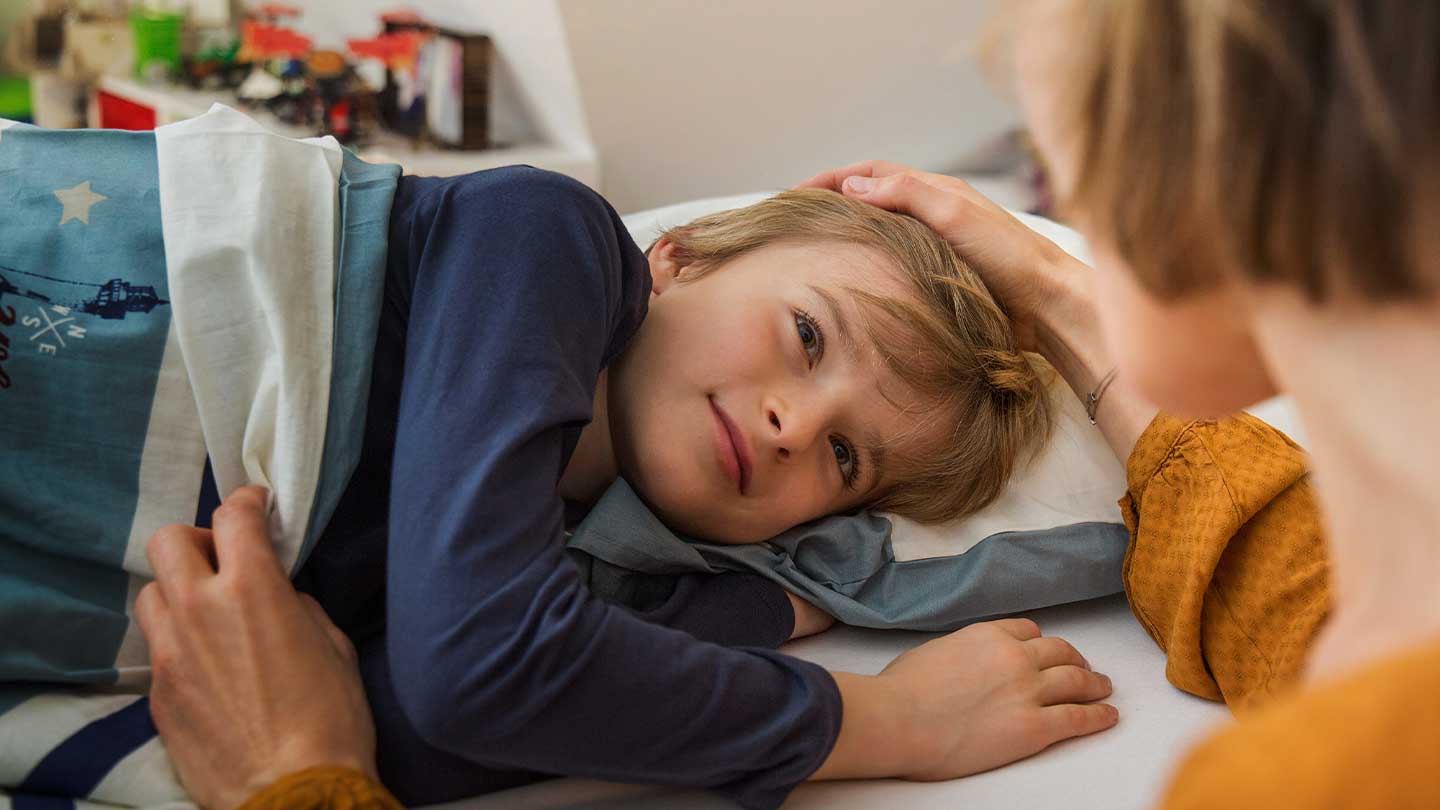 Kind liegt im Bett.