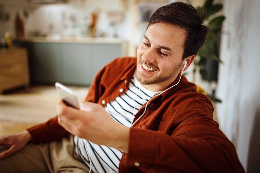 Junger Mann auf Couch mit Handy